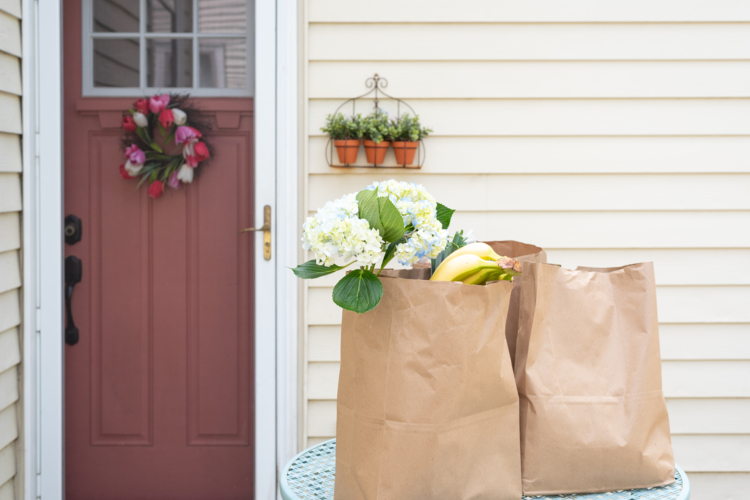 Grocery delivery in paper bags outside home entrance - safe, contactless food delivery