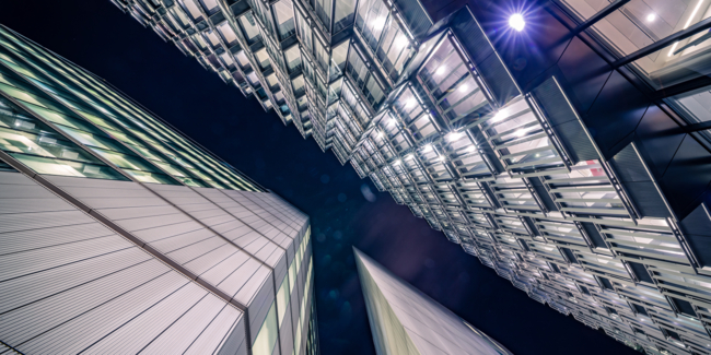 Highly detailed abstract wide angle view up towards the sky in the financial district of London City and its ultra modern contemporary buildings with unique contemporary architecture during night time. Shot on Canon EOS R full frame with 14mm wide angle prime lens. Image is ideal for background with copy space and no people.