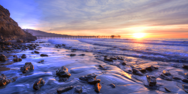 Colorfully vivid scenic southern California beach featuring Scripps pier in La Jolla at sunset with beautiful relfections