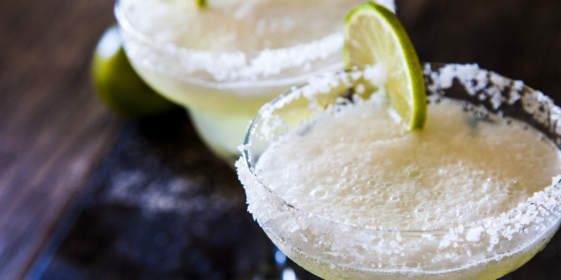 two frozen margaritas with lime and salt